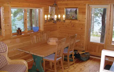 a dining room with a wooden table and chairs at Roligheten in Vanvik