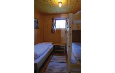 a room with two bunk beds and a table at Roligheten in Vanvik