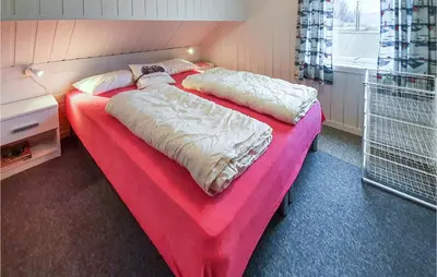 a bedroom with two beds with a red blanket at 3 Bedroom Awesome Home In Skjold in Skjold