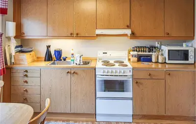 a kitchen with a white stove and a microwave at 3 Bedroom Awesome Home In Skjold in Skjold