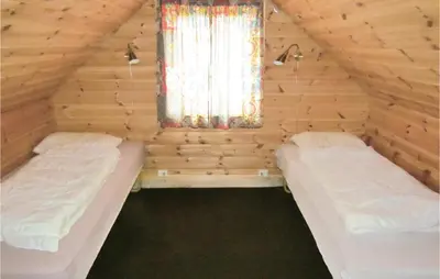two beds in a wooden room with a window at Holiday Home Bjoa Haugsgjerdet in Utbjoa