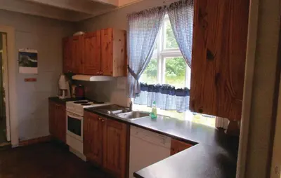 a kitchen with wooden cabinets and a sink and a window at Holiday Home Bjoa Haugsgjerdet Ii in Utbjoa