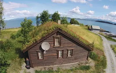 a house with a grass roof with a satellite at 3 Bedroom Gorgeous Home In Bjoa in Utbjoa