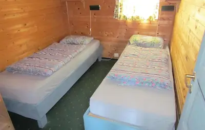 two beds in a room with wooden walls at 3 Bedroom Gorgeous Home In Bjoa in Utbjoa