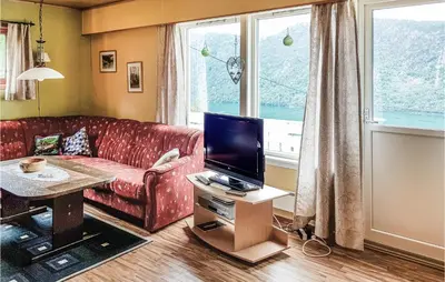 a living room with a red couch and a tv at Ytre Matre in Hamre