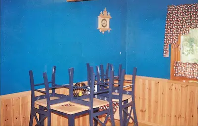 a dining room with a table and chairs and a clock at Holiday Home Etne Sørstranda in Erve