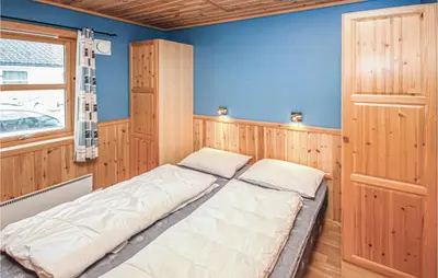 a large bed in a room with a blue wall at Amazing Home In Auklandshamn With Sauna in Vestvik