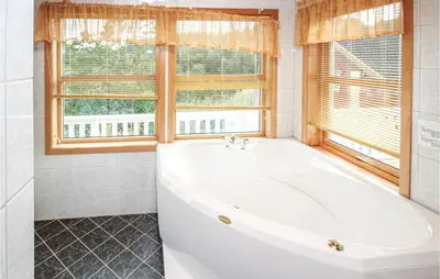 a white bath tub in a bathroom with a window at Amazing Home In Auklandshamn With Sauna in Vestvik