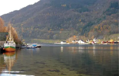a group of boats sitting in a body of water at Vågen 1 in Åkra