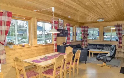 a dining room and living room with a table and chairs at Vågen 1 in Åkra