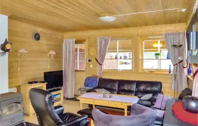 a living room with a leather couch and a table at Gorgeous Home In Åkra With Wifi in Åkra