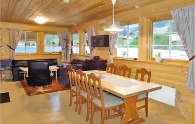 a dining room with a table and chairs and a couch at Gorgeous Home In Åkra With Wifi in Åkra