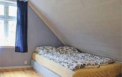 a bed in a room next to a window at Galanten in Grimsland