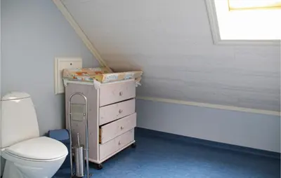 a bathroom with a toilet and a dresser with a box on it at Galanten in Grimsland