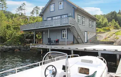a boat docked in front of a house on a dock at Galanten in Grimsland