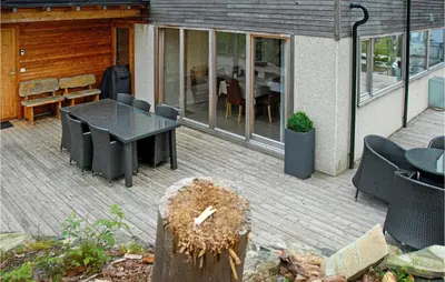 a patio with a black table and chairs on it at 3 Bedroom Awesome Home In Mosterhamn in Mosterhamn