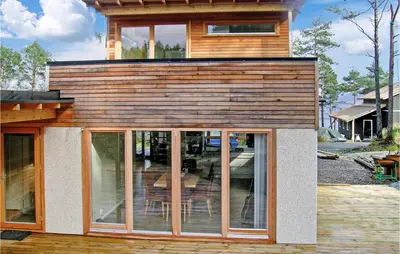 a house with glass doors on the side of it at 3 Bedroom Awesome Home In Mosterhamn in Mosterhamn