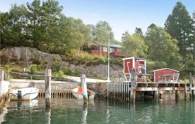 a dock with two boats tied to it in the water at Awesome Home In Sandvoll in Sandvoll