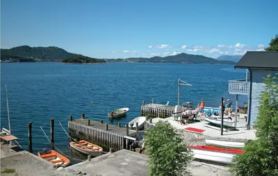 a group of boats parked at a dock on a lake at Stunning Home In Sandvoll in Sandvoll