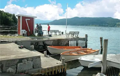 two boats are docked at a dock on a lake at Nice Home In Sandvoll in Sandvoll