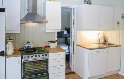 a kitchen with white cabinets and a stove top oven at Nice Home In Etne With House Sea View in Erve