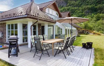 a deck with a table and chairs and an umbrella at Nice Home In Lundegrend With Wifi in Grimsland
