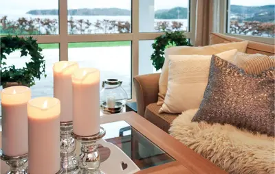 a living room with a couch and candles on a table at Nice Home In Lundegrend With Wifi in Grimsland