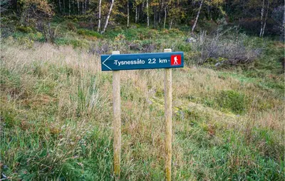 a blue street sign in the middle of a field at Nice Home In Lundegrend With Wifi in Grimsland
