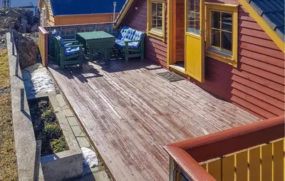 a deck with two chairs and a table on a house at Holiday Home Finnås Lyklingsjøvegen in Vinnes
