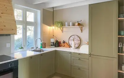 a kitchen with green cabinets and a sink and a window at Holiday Home Finnås Lykling in Vinnes