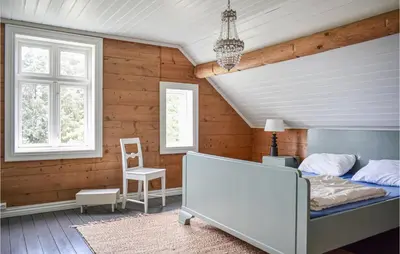 a bedroom with a bed in a room with wooden walls at Holiday Home Finnås Lykling in Vinnes