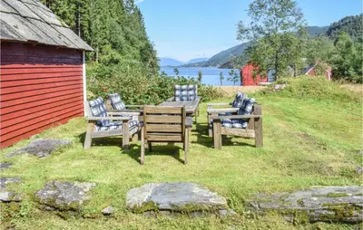 a group of benches sitting next to a building at Holiday Home Nordtveitgrend Nedrevågen in Hjartåker