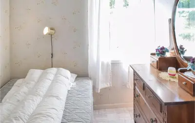 a bed in a room with a mirror and a dresser at Holiday Home Nordtveitgrend Nedrevågen in Hjartåker