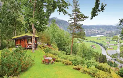 a cabin on a hill with a table and chairs at Cozy Home In Norheimsund in Norheimsund