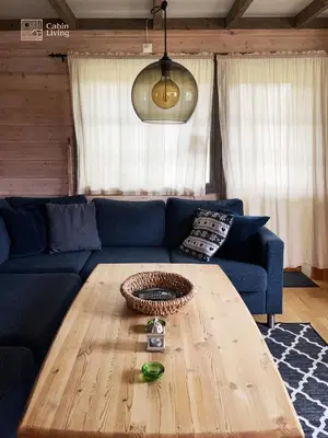 a living room with a blue couch and a wooden table at Nice apartment in Trysil ski in-out, sauna and view in Trysil