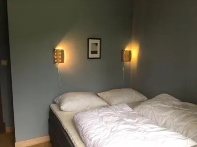 a bed in a room with two lamps on the wall at Nice apartment in Trysil ski in-out, sauna and view in Trysil