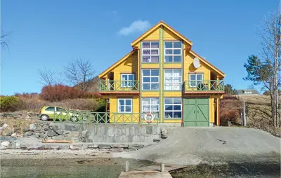 a yellow house with a green door and a car at Cozy Apartment In Rosendal in Rosendal