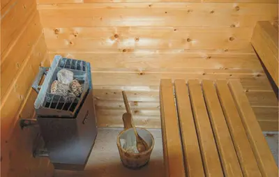 an inside view of a sauna with a bench and a grill at Nice Apartment In Rosendal With Sauna in Rosendal