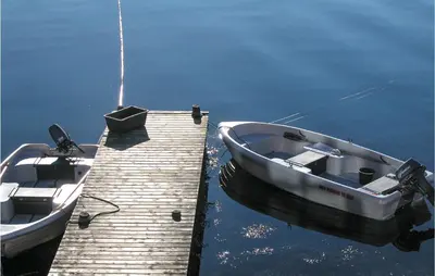 two boats are docked at a dock on the water at Nice Apartment In Rosendal With Sauna in Rosendal