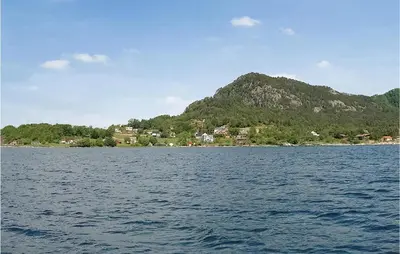 a large body of water with a mountain in the background at Eikhaugen Gjestegard in Husa