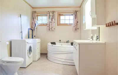 a bathroom with a toilet a sink and a washing machine at Eikhaugen Gjestegard in Husa