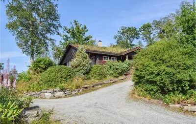 a house on a hill with a gravel road at Eikhaugen Gjestegard in Husa