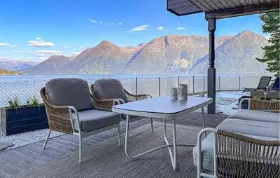 a patio with chairs and a table and a view of the water at Raaen Hytteutleige in Utne