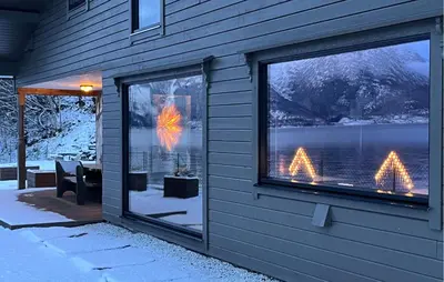 a building with a view of a lake and a table at Raaen Hytteutleige in Utne