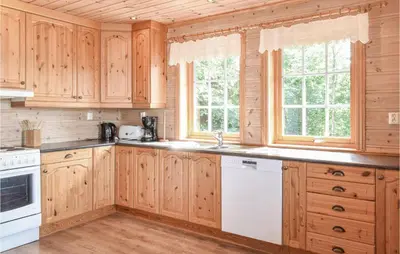 a kitchen with wooden cabinets and white appliances at Eikhaugen Gjestegard in Husa