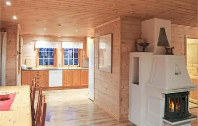 a kitchen with a fireplace in a wooden house at Eikhaugen Gjestegard in Husa