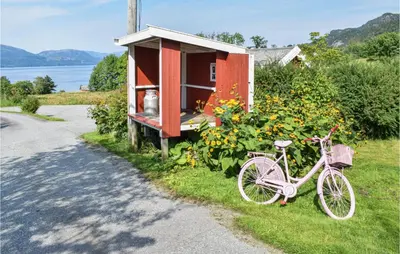 a pink bike parked in front of a small house at Eikhaugen Gjestegard in Husa