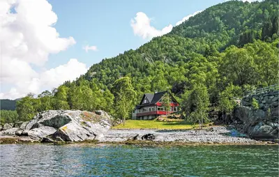 a house on the shore of a body of water at Amazing Home In Nordtveitgrend in Hjartåker