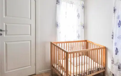 a crib in a room next to a window at Amazing Home In Nordtveitgrend in Hjartåker