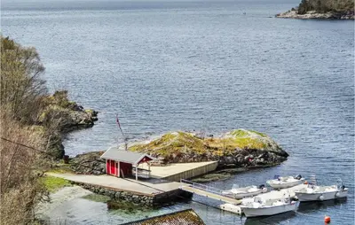 a dock with boats in a body of water at Amazing Home In Nordtveitgrend in Hjartåker
